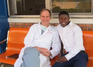El Dr. Ralph Bolman (EE.UU.), miembro de la STS, con un paciente que anteriormente fue sometido a una cirugía doble de válvula y ahora es estudiante de medicina en Rwanda. Foto cortesía del Team Heart.